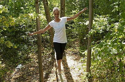 Person auf Slackline im Wald