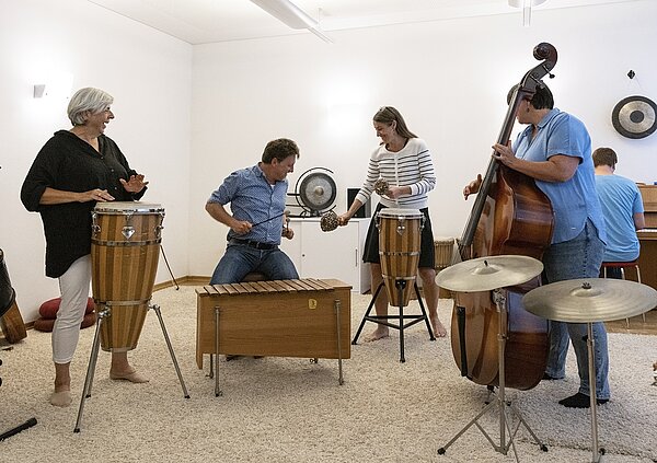 Gruppenfoto von musikspielenden Personen mit Instrumenten